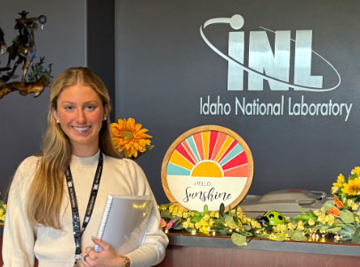 Lillian Beck poses with INL sign in background