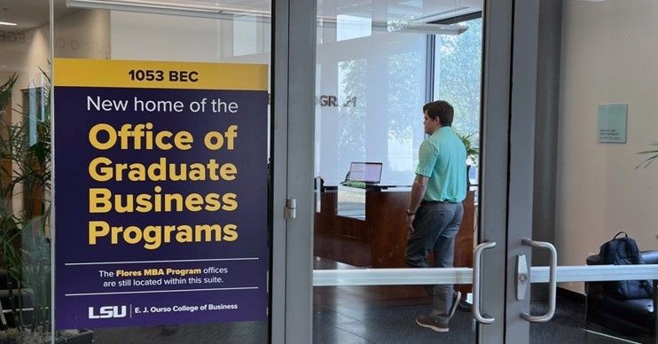 The door to a suite with a sign that reads "New home of the Offfice of Business Graduate Programs"