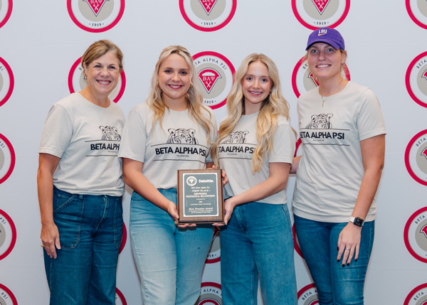 he LSU BAP chapter and their advisor stand in front of a BAP branded step-and-repeat wearing BAP t-shirts. They hold the plaque for the first place Best Practices Award.