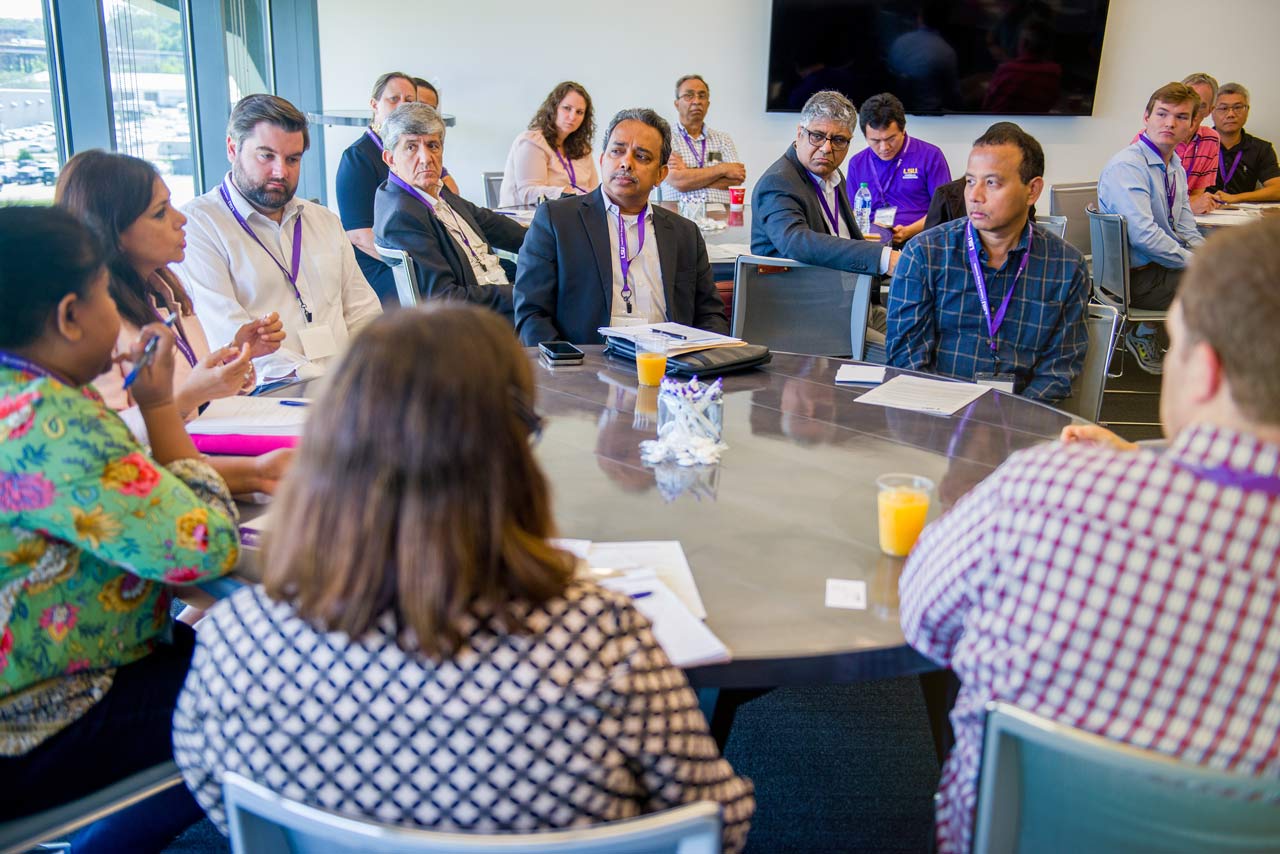 Woman leading a group discussion featuring business people and research scientists