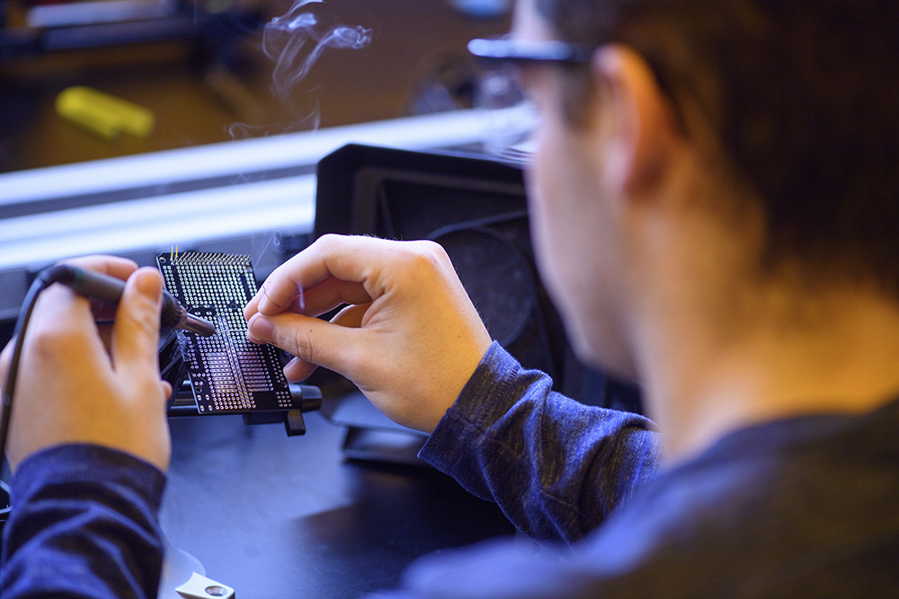 Electrical engineering student works on circuit board