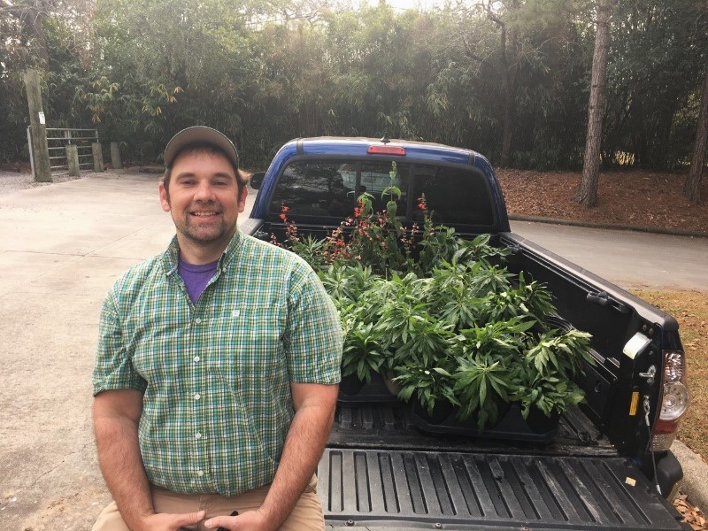 Dan Cooke by truckbed filled with wildflowers