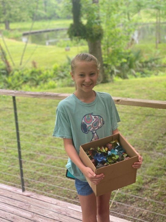 Laxi Balsam holding box filled with oragami flowers she made